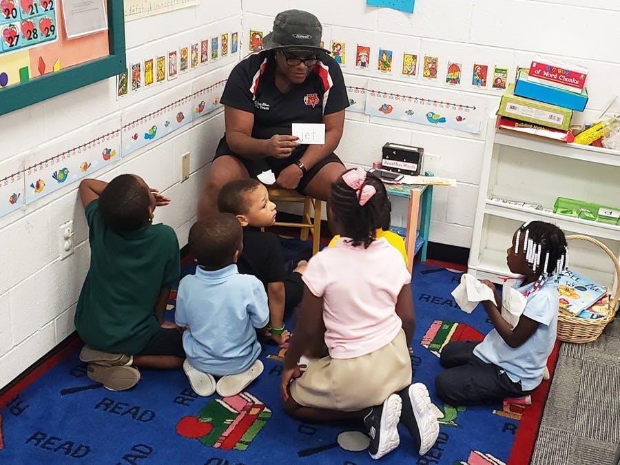 GYAC volunteer practicing site words with the Kindergarten Class